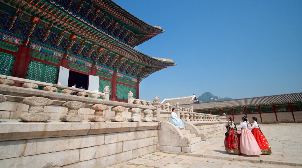 Gyeongbok Palace showing heritage elements and a square or plaza as well as a small group of people