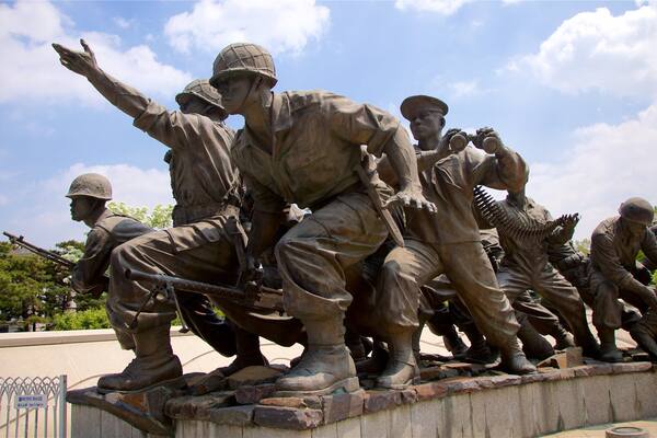 Une statue en bronze représentant des soldats dans différentes poses, dont l’un pointant vers le haut et un autre tenant des jumelles.