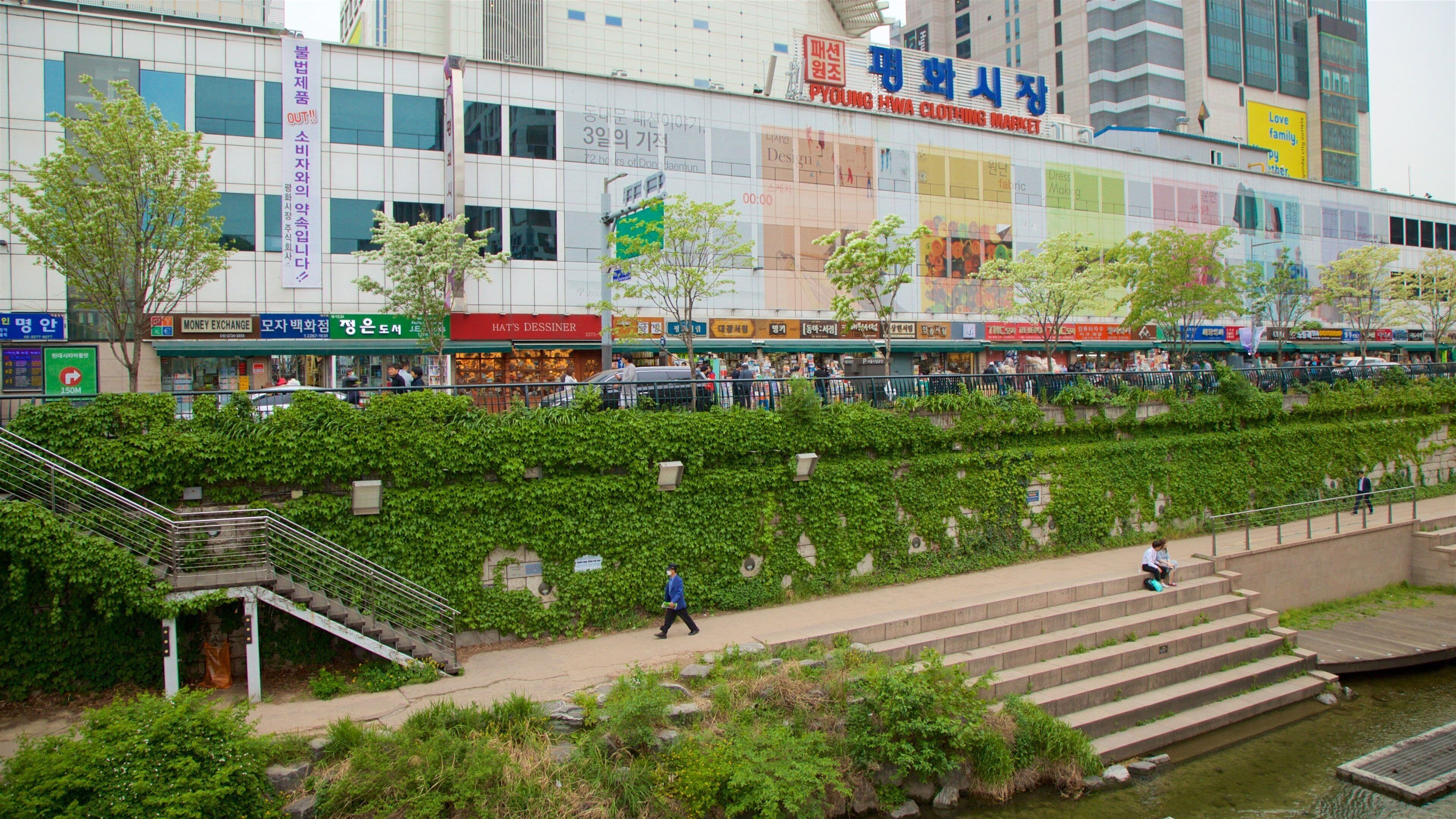 Un centro comercial con varias tiendas y una escalera que baja hacia un río.
