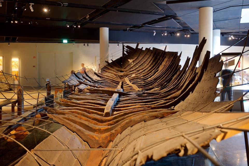 Una gran estructura de barco de madera en una exposición interior.