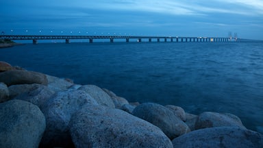 Un puente sobre el agua, con rocas grandes al frente.