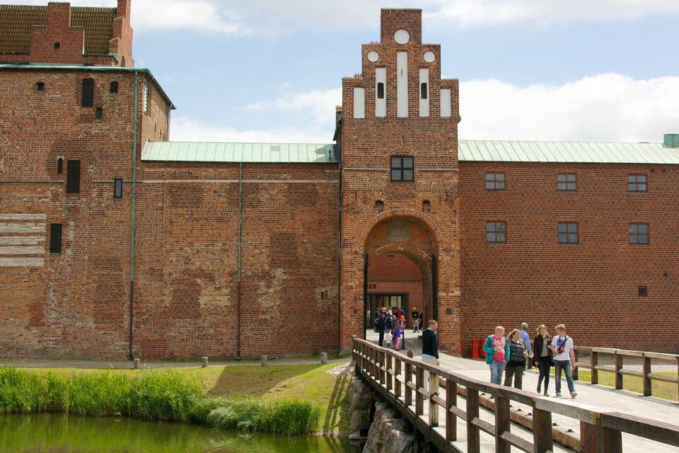 A historic brick building with a prominent archway and a clock tower.