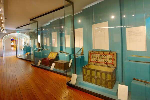 Um corredor de museu com vitrines de vidro exibindo artefatos históricos.