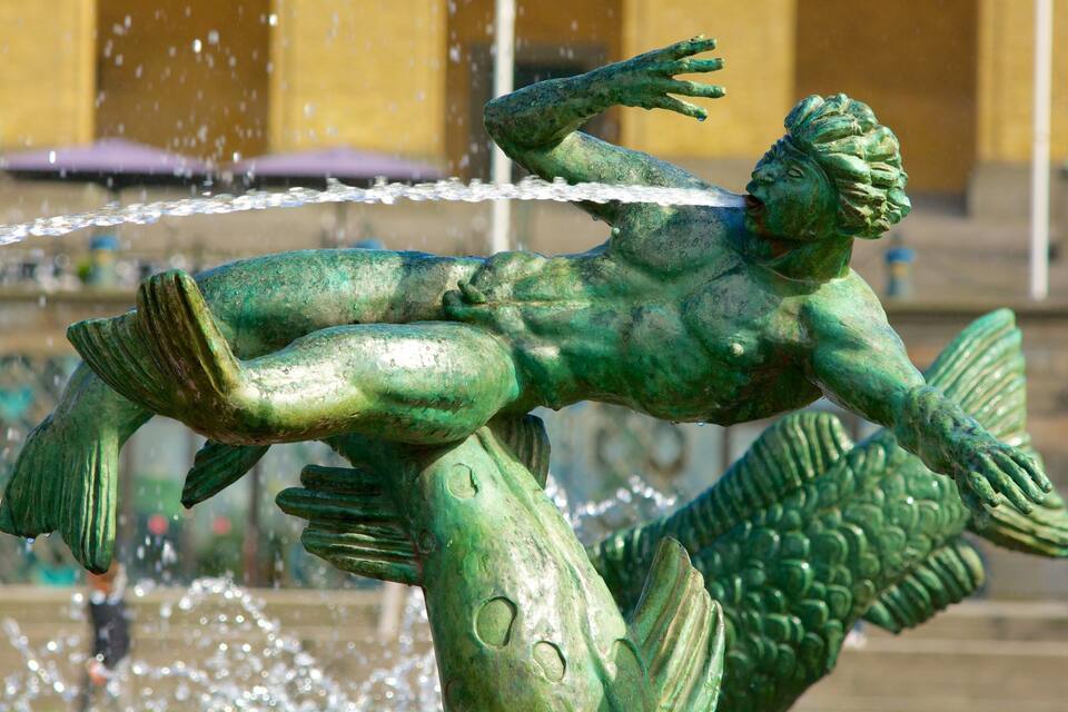 Uma estátua de bronze de uma sereia com água jorrando da cauda.