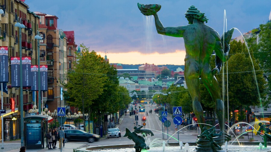 Poseidon-statyn presenterar en staty eller skulptur, en fontÀn och gatuliv