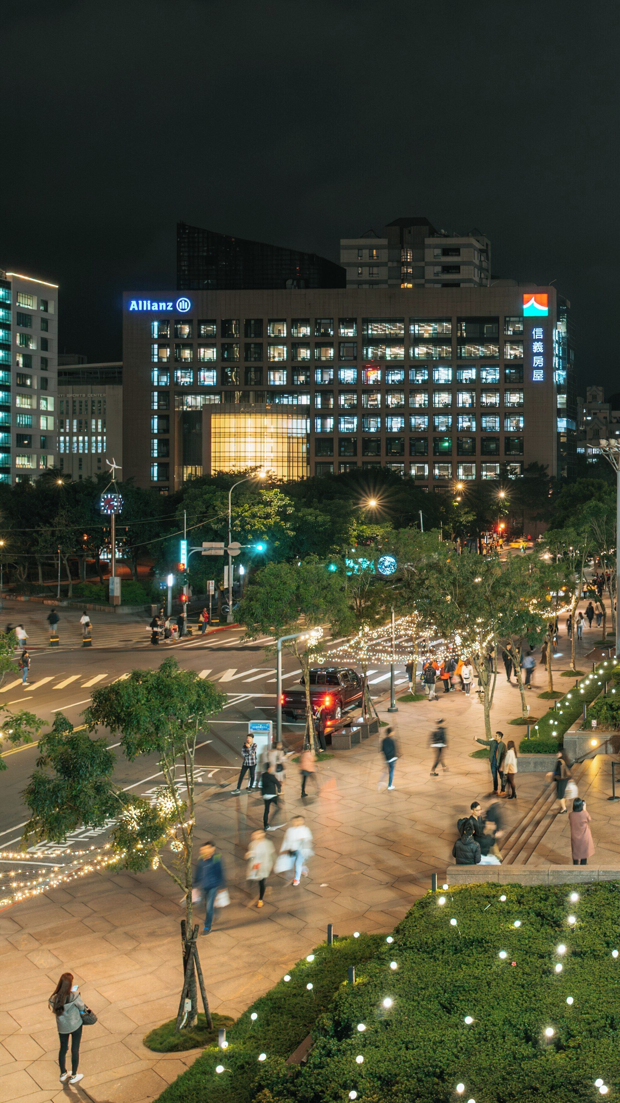 Nighttime view of Taipei 101 and bustling streets in Xinyi District, Taipei, Taiwan, highlighting urban life and vibrant atmosphere