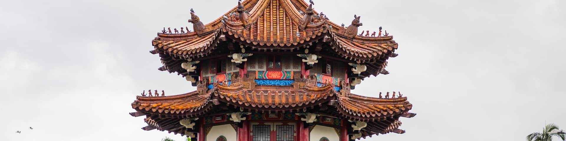 A multi-tiered pagoda with intricate roof designs and red pillars.