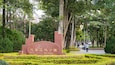 A park with a large stone monument surrounded by lush greenery and trees.