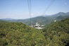 A cable car system in a mountainous area with dense green forests.