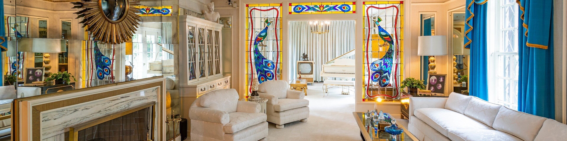 Una sala de estar lujosa con una chimenea imponente, muebles elegantes y vidrieras de colores.