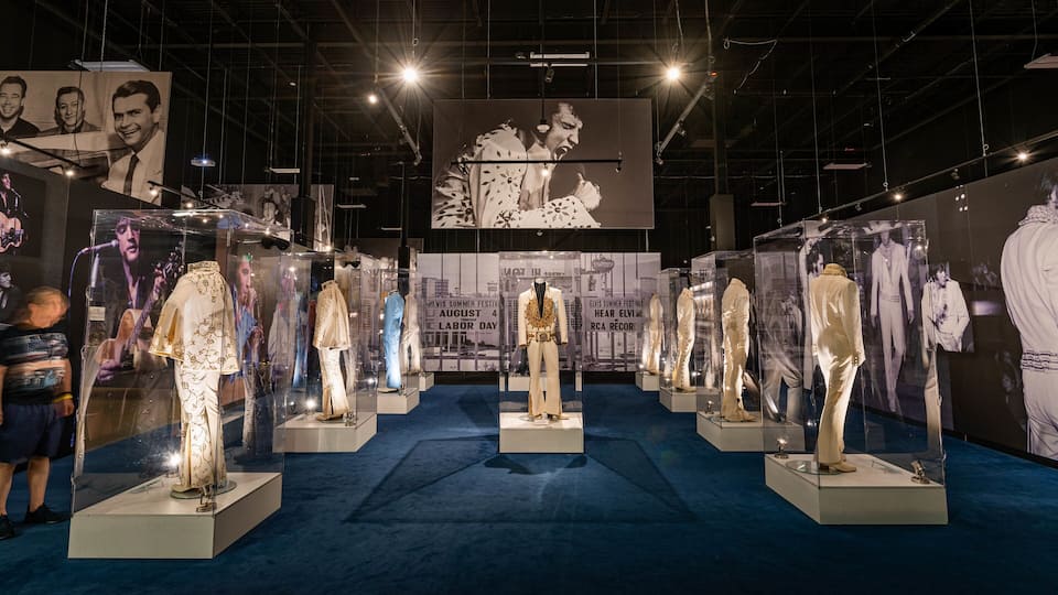 Une exposition de musée présentant des costumes portés par Elvis Presley.