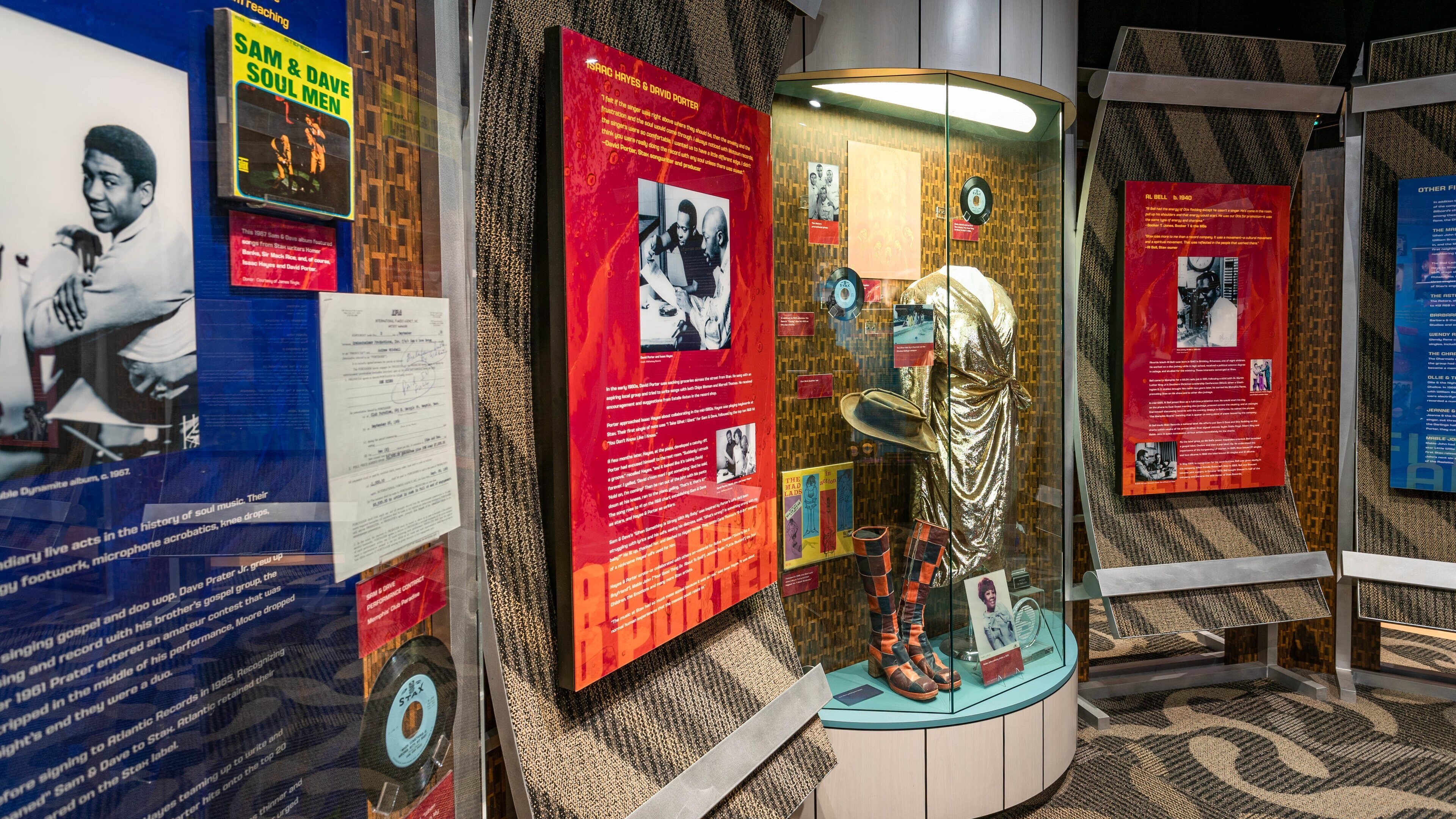 Eine Museumsausstellung mit Informationstafeln, einer goldenen Statue und einer Vitrine mit Aufzeichnungen.