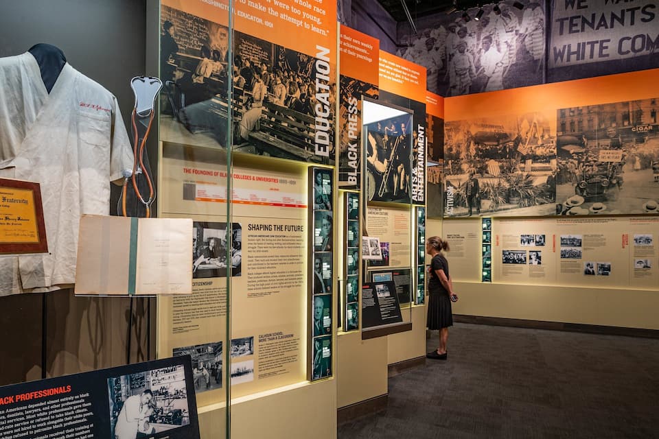 Een educatieve tentoonstelling met historische foto's, documenten en een display van een witte labjas.