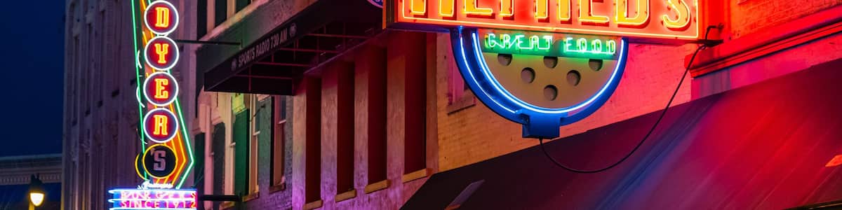 Enseignes lumineuses au néon pour le restaurant ALFRED'S, avec les mentions « MUSIQUE LIVE » et « EXCELLENTE CUISINE ».