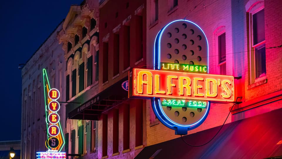 Neon signs for ALFRED'S restaurant, including 'LIVE MUSIC' and 'GREAT FOOD'.
