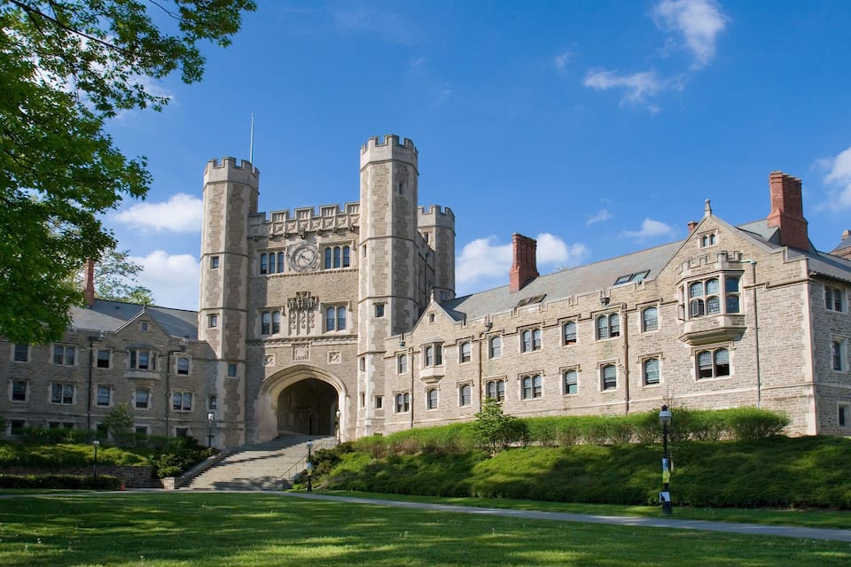 A large stone building with two towers and a clock tower.