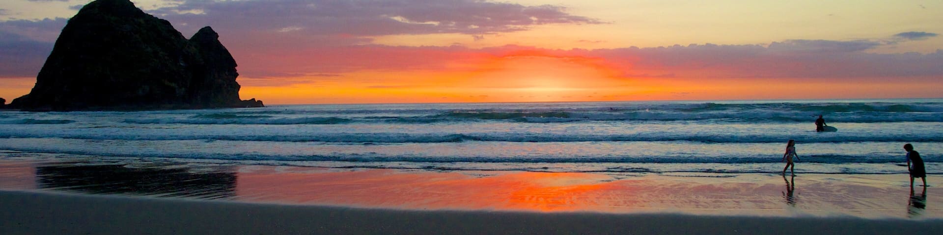 Piha Beach showing landscape views, a sandy beach and swimming