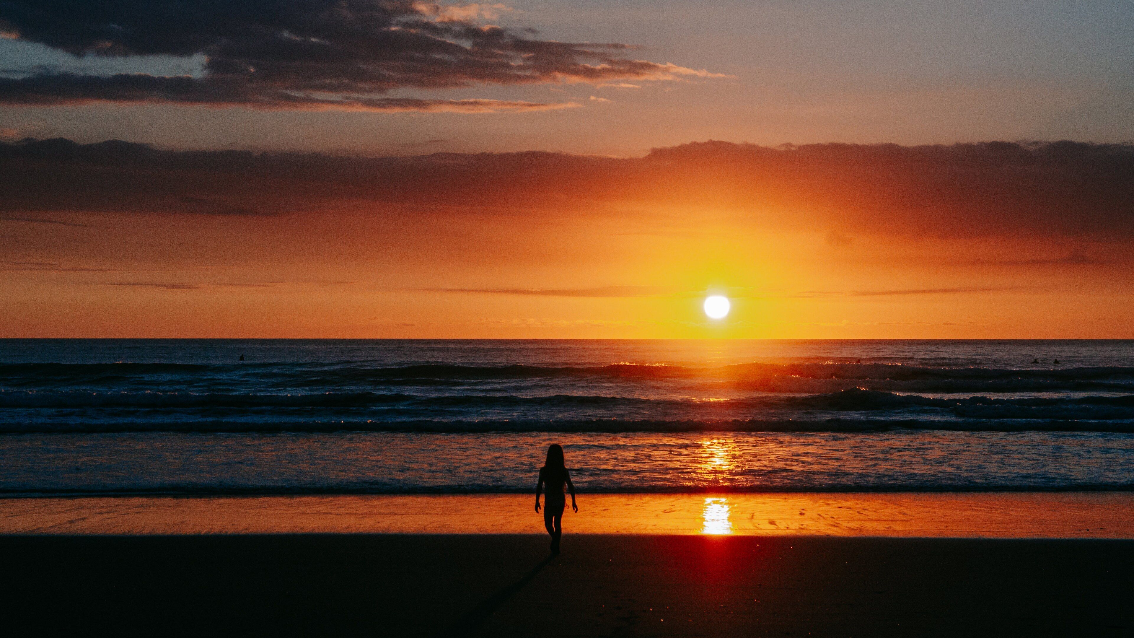 Piha Beach which includes general coastal views and a sunset as well as an individual femail