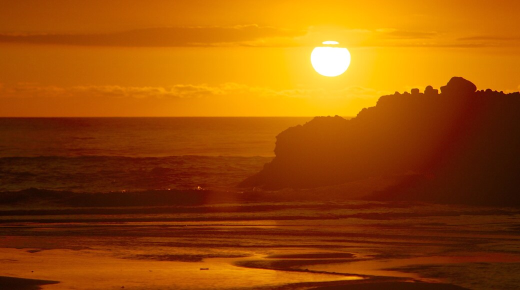 Piha Beach das einen allgemeine Küstenansicht und Sonnenuntergang