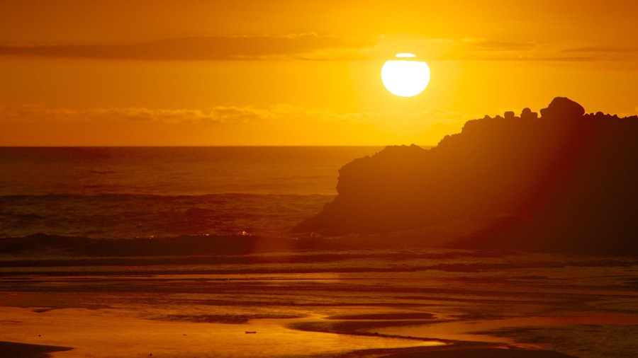 Piha Beach showing general coastal views and a sunset