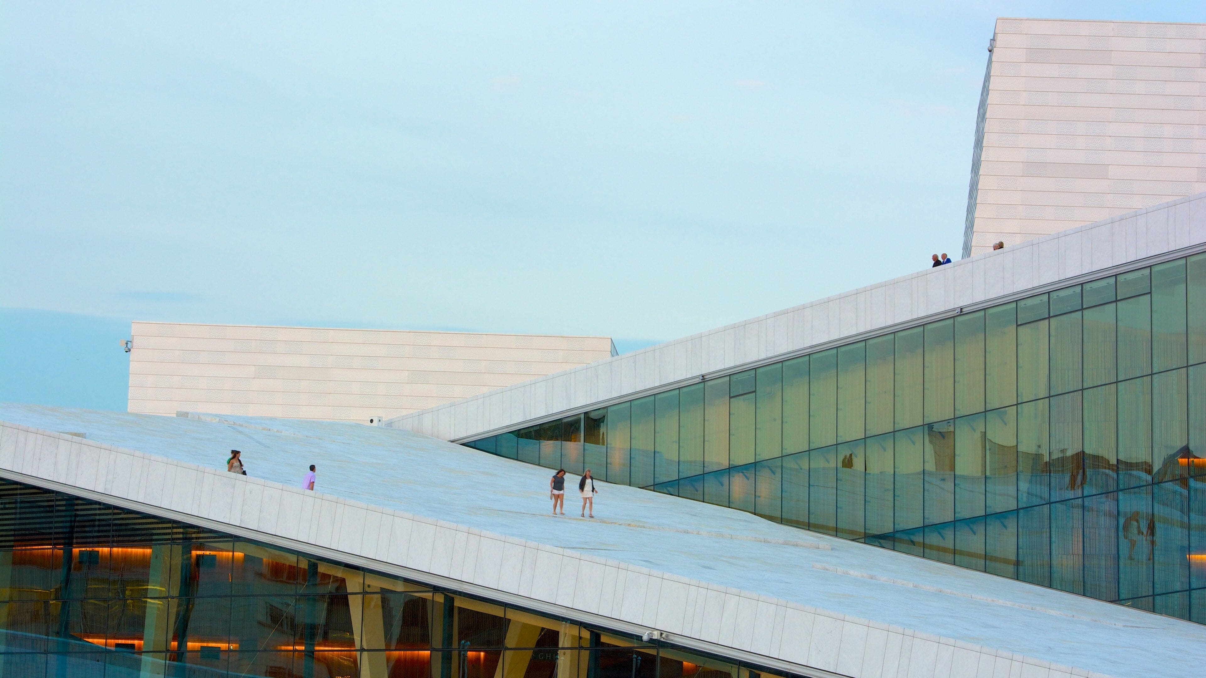 A modern architectural building with glass facades and a sloped roof.