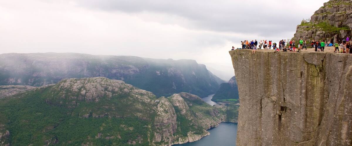 Une falaise où se trouve une foule de personnes, rassemblées au bord.