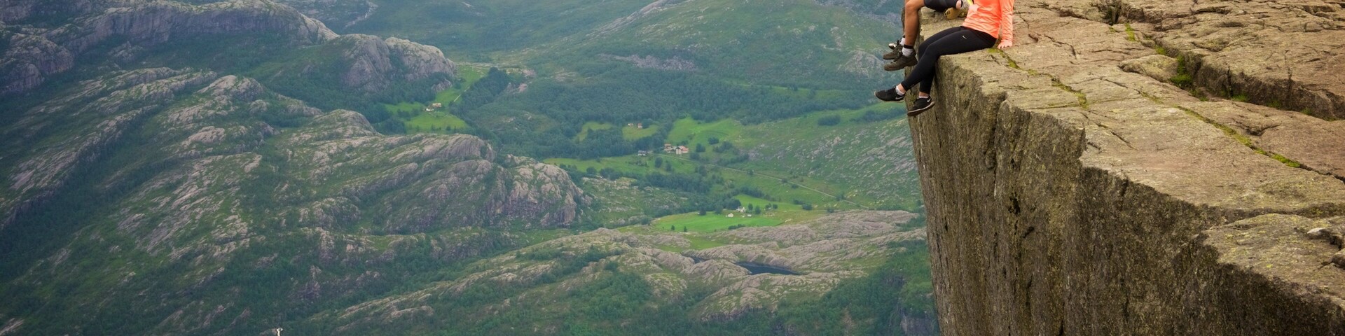 Preikestolen showing a lake or waterhole and views as well as a small group of people