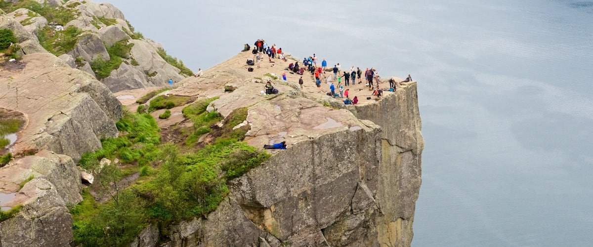 Preikestolen which includes a lake or waterhole and views as well as a large group of people