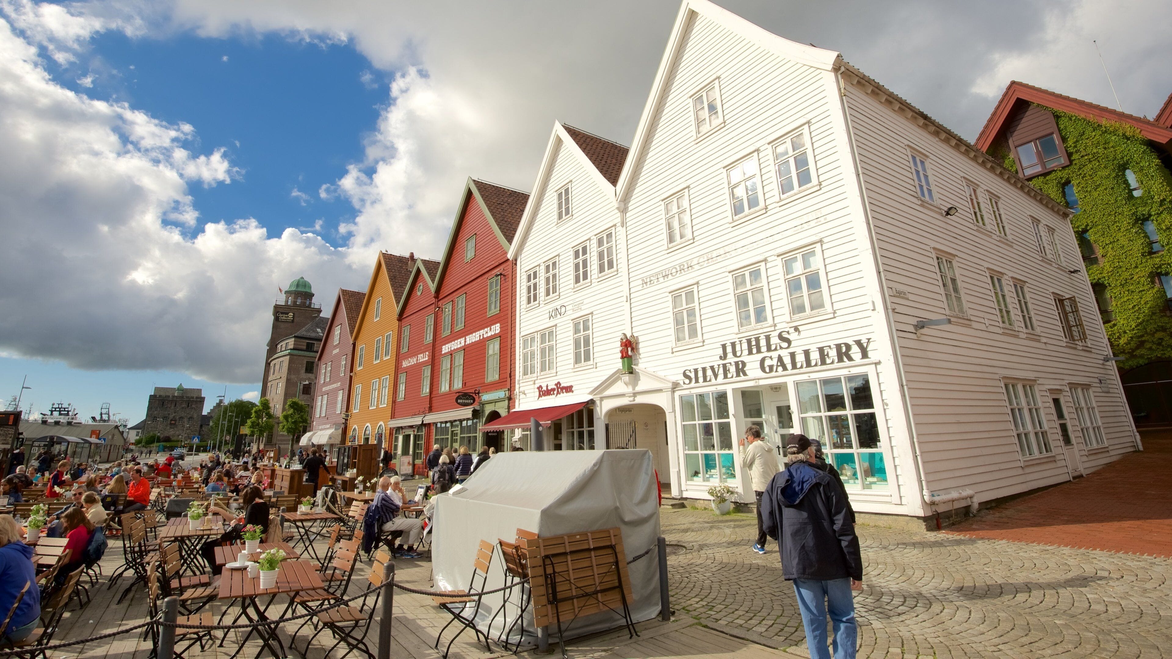 Bryggen which includes outdoor eating and a small town or village as well as a large group of people