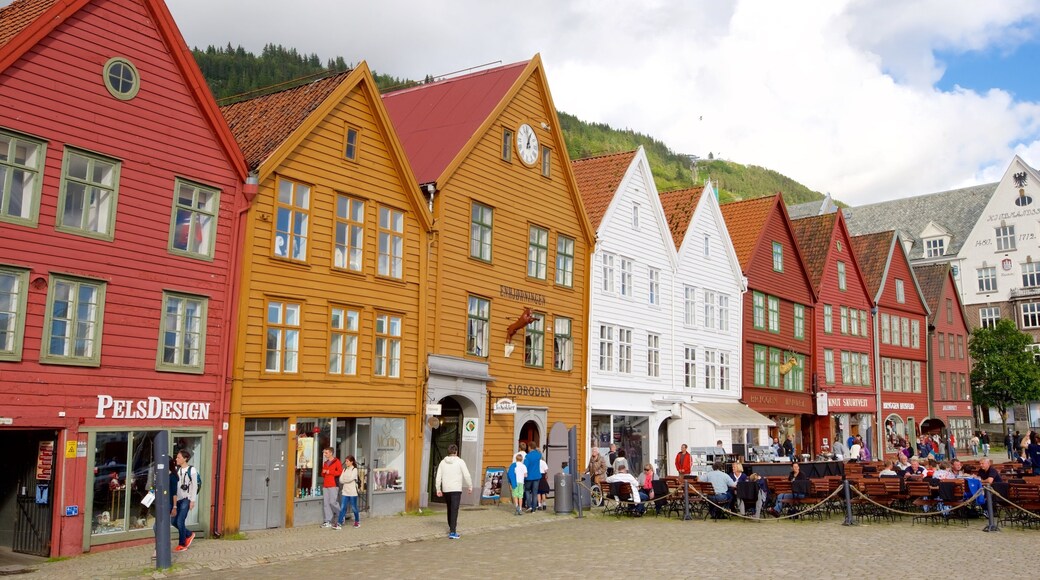 Bryggen mostrando una pequeña ciudad o pueblo y comer al aire libre y también un gran grupo de personas