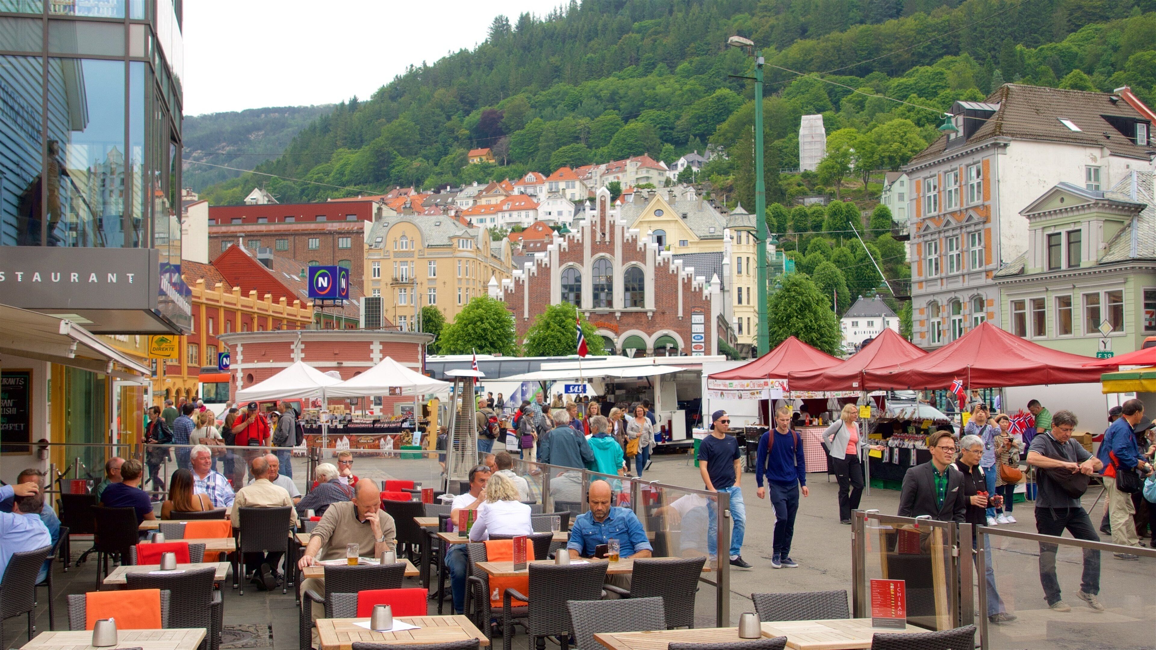 Torget Fishmarket showing a square or plaza and outdoor eating as well as a small group of people