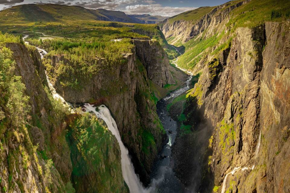 A canyon with a waterfall and a river.