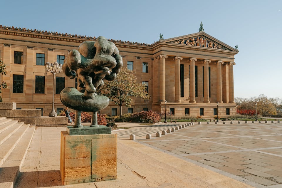 Um edifício clássico com uma grande escultura em frente.
