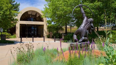 The Gilcrease Museum with a statue of a man holding a ring in front of it.