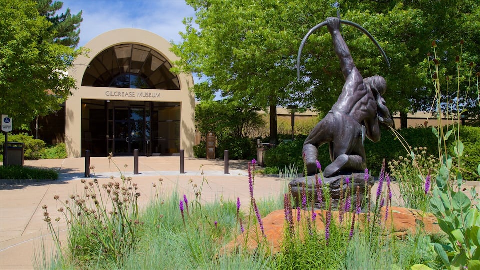 The Gilcrease Museum with a statue of a man holding a ring in front of it.