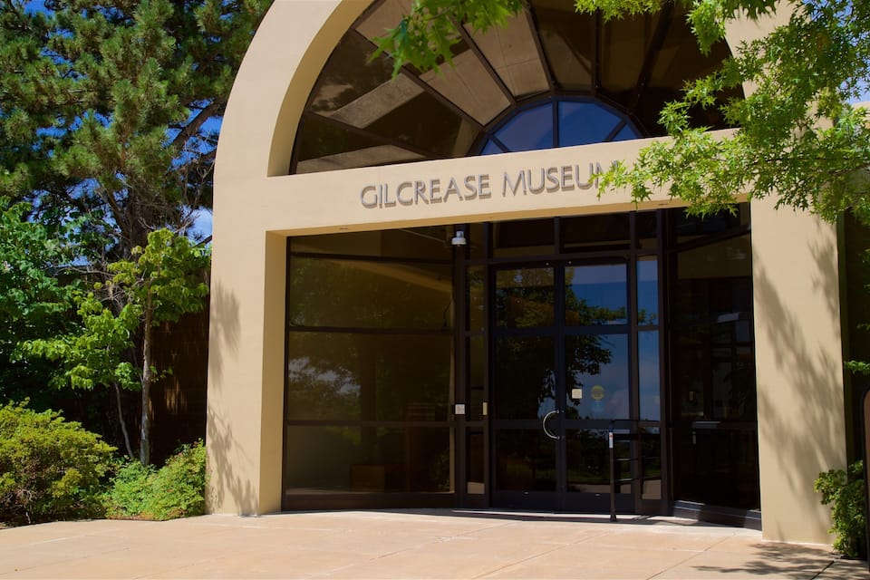 The entrance to the Gilcrease Museum with a large arched doorway and a sign above it.