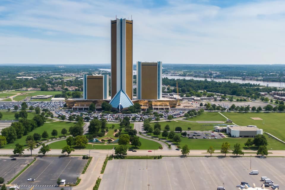 Un ampio parcheggio, un edificio centrale dal design particolare e un fiume sullo sfondo.