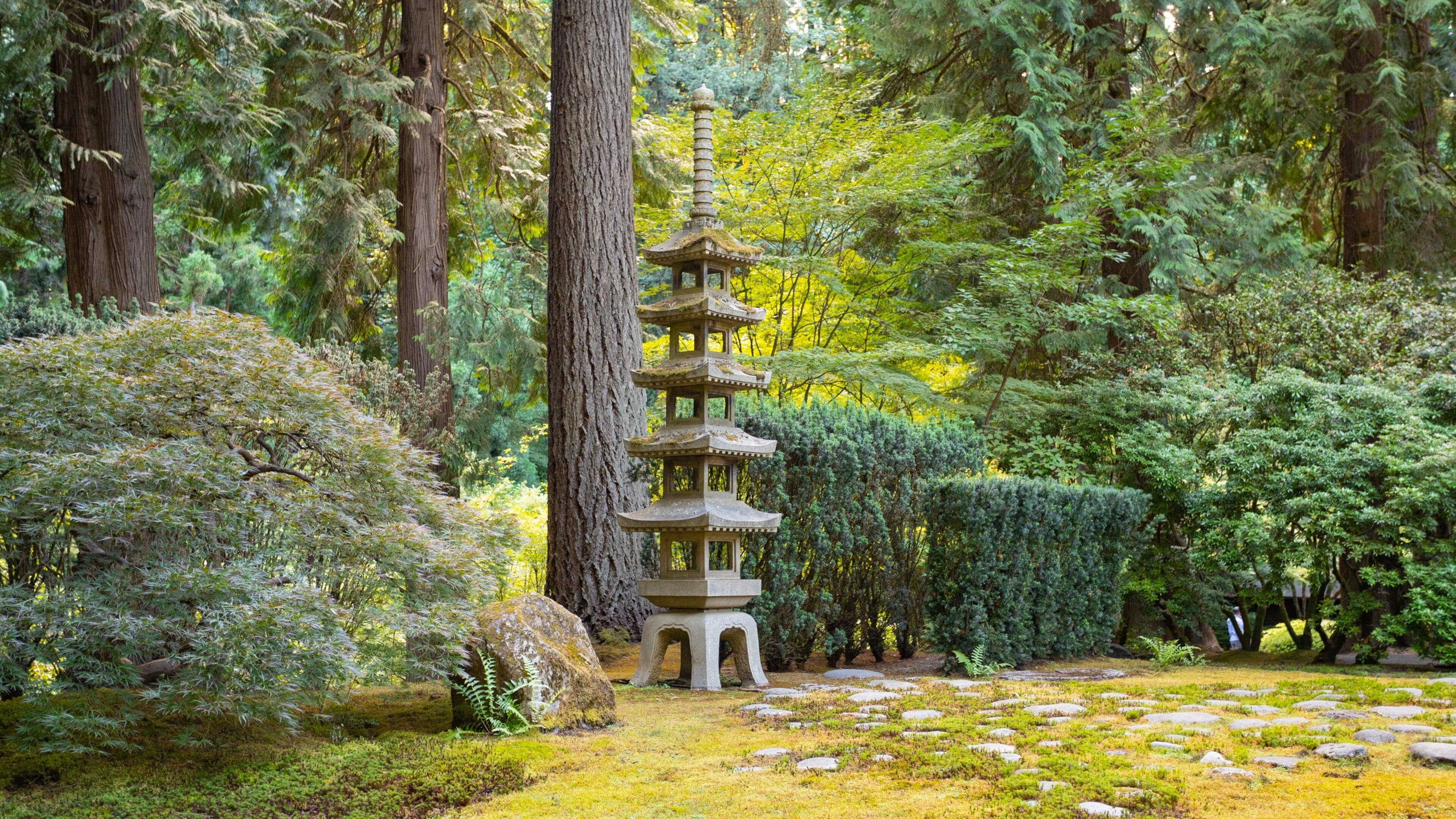 Eine traditionelle japanische Pagode, umgeben von üppigem Grün und Felsen.