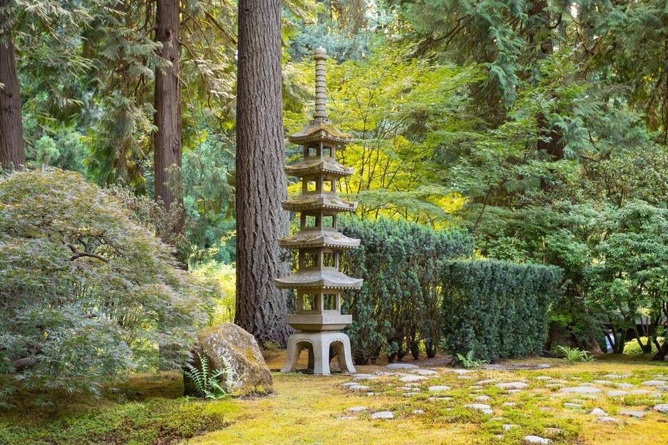 Eine traditionelle japanische Pagode, umgeben von üppigem Grün und Felsen.