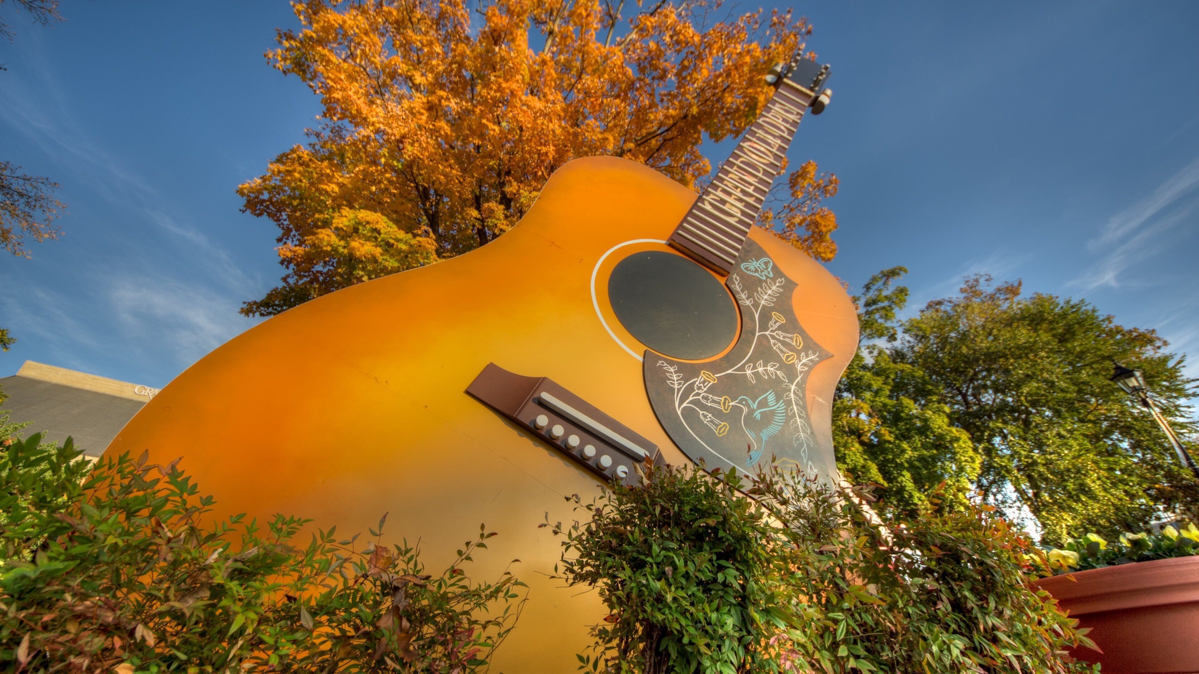 Grand Ole Opry showcases iconic guitar sculpture surrounded by autumn foliage in Nashville, Tennessee