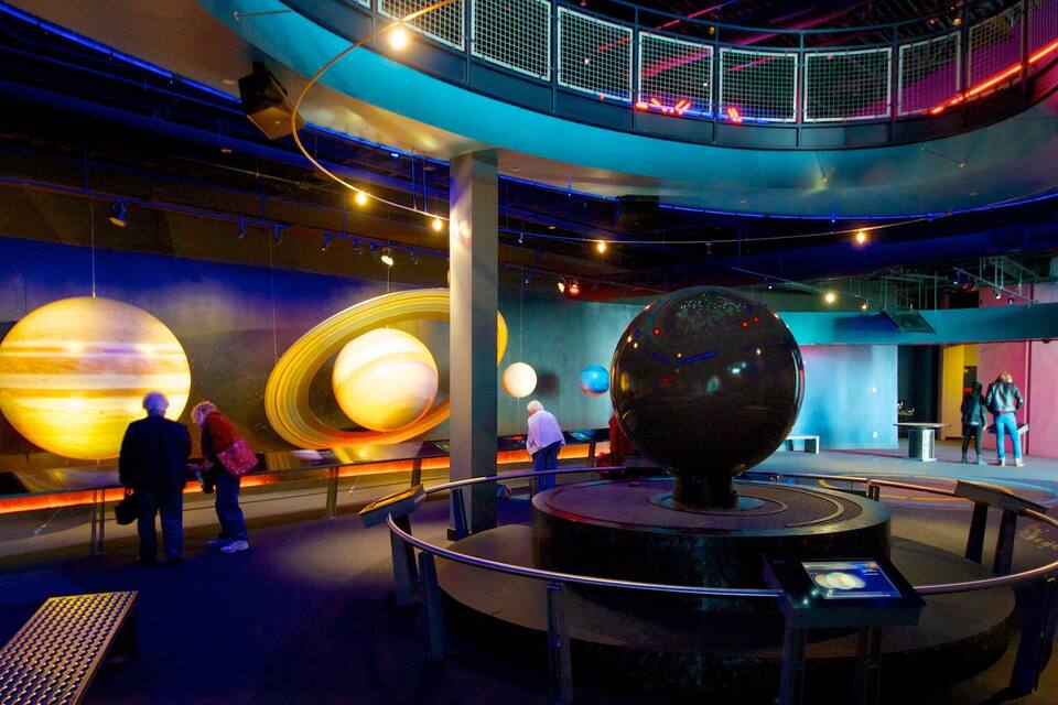A museum with large planetary models and a spherical exhibit.
