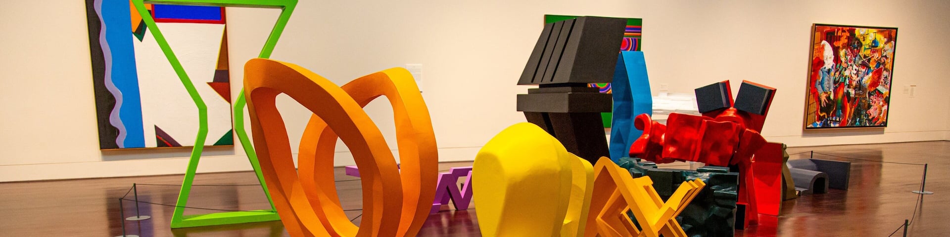 An art gallery with abstract sculptures and colorful paintings.