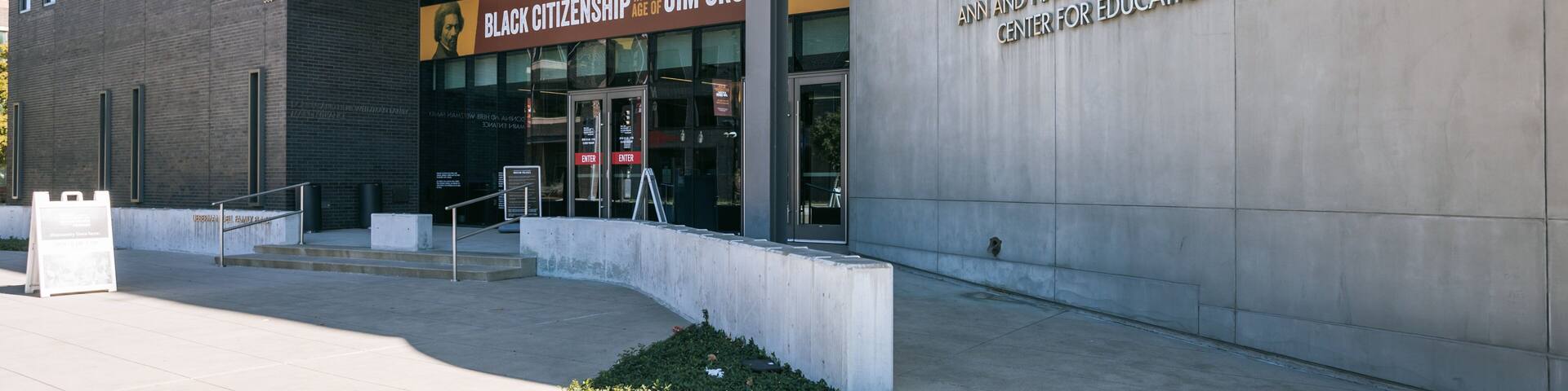 The exterior of the Dallas Holocaust and Human Rights Museum, featuring a modern architectural design with a prominent entrance and signage.