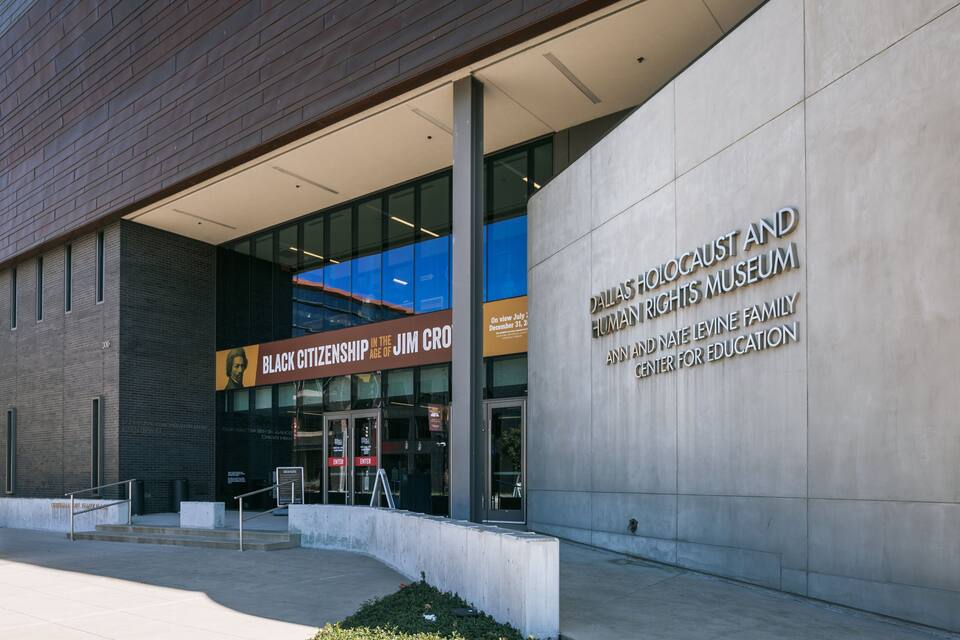 Esterno del Museo dell'Olocausto e dei Diritti Umani di Dallas, caratterizzato da un design architettonico moderno con un ingresso e una segnaletica ben visibili.