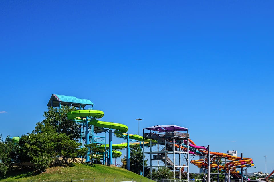 Un parc aquatique doté de nombreux toboggans et surplombé d’un ciel bleu.