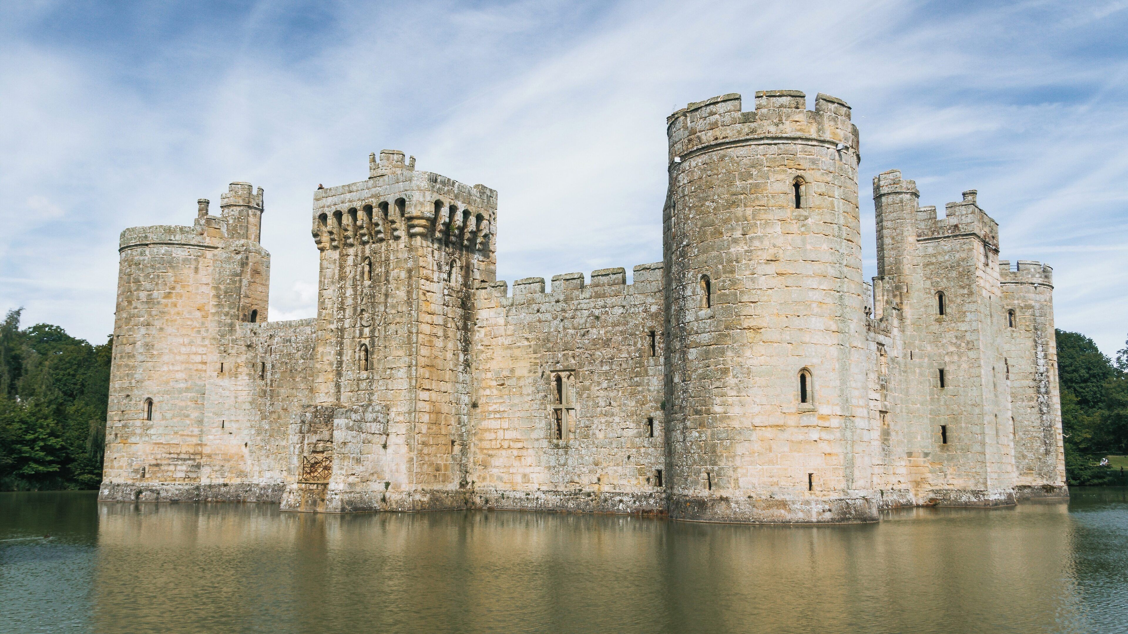 Bodiam Castle standing majestically in Robertsbridge, England, surrounded by a serene moat under a clear sky