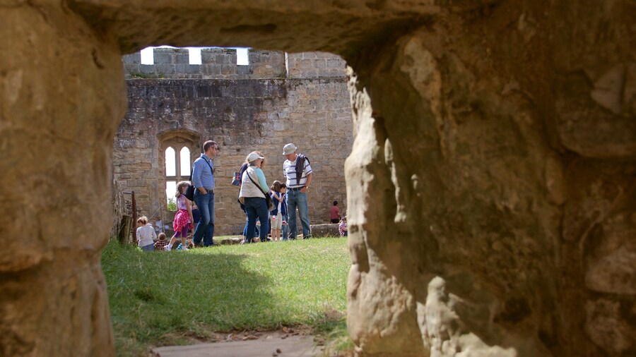 Bodiam Castle featuring heritage elements and a castle as well as a small group of people
