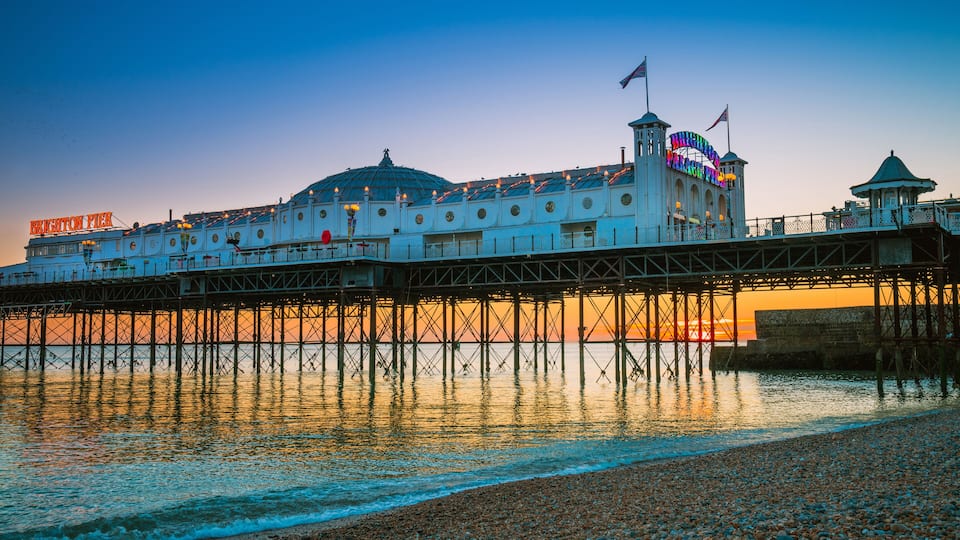 Brighton Pier beach with sunset golden hour at Sussex England, UK. Brighton Marine Palace and Pier popular place for visitor.