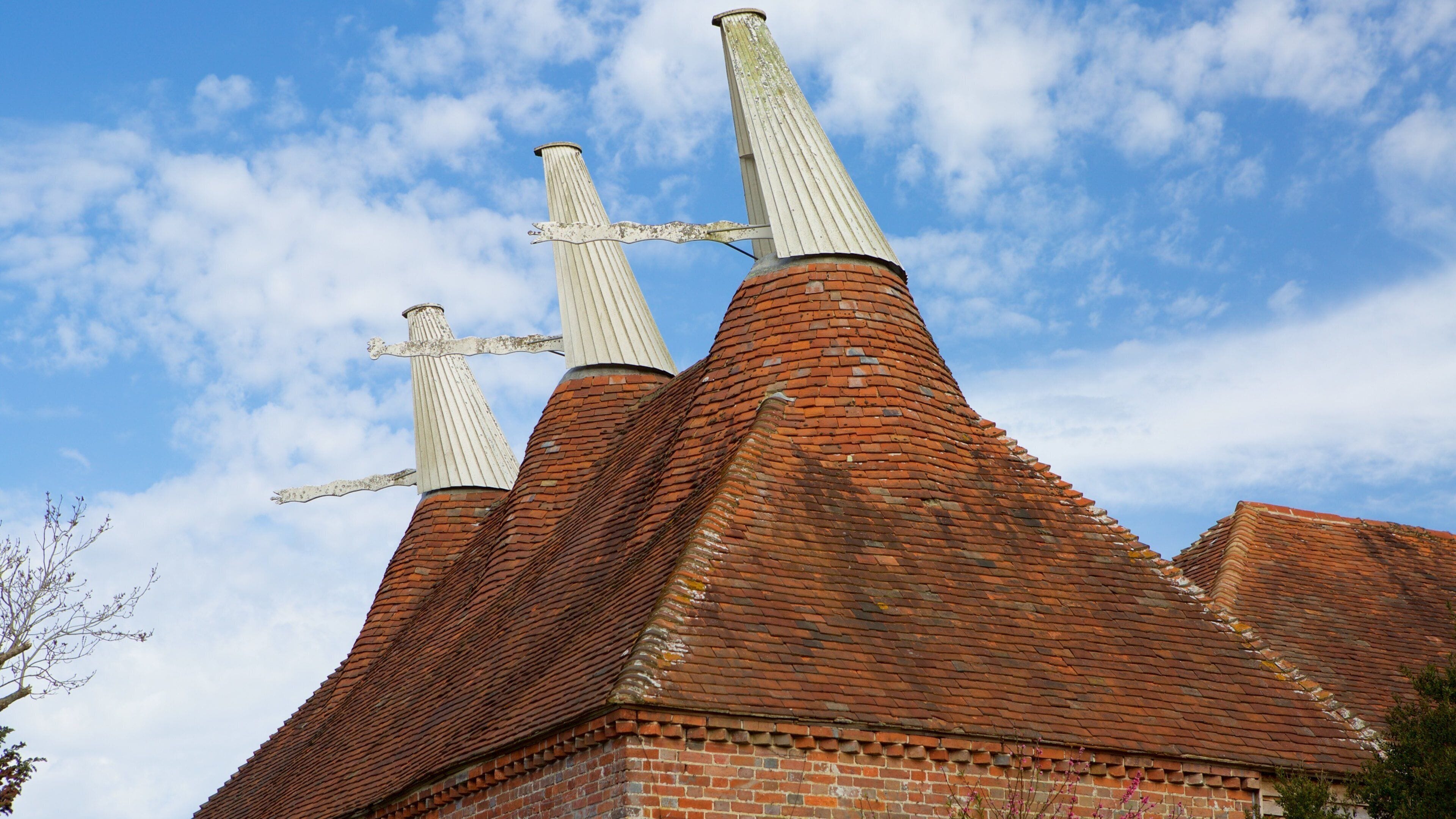 A brick building with two chimneys and a clear blue sky.