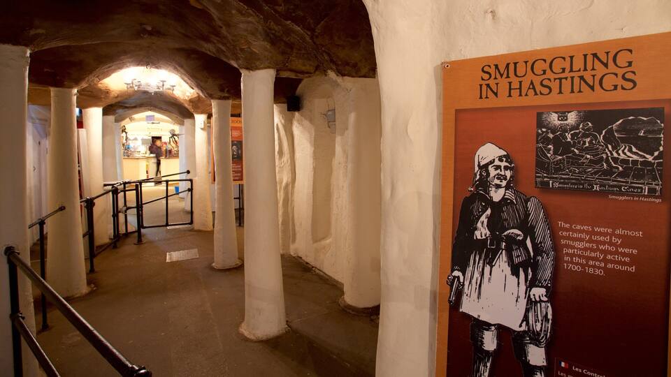 Exhibición histórica sobre el contrabando en Hastings, con un cartel que muestra a un hombre sosteniendo un arma y texto sobre el uso de cuevas para el contrabando entre 1700 y 1830.
